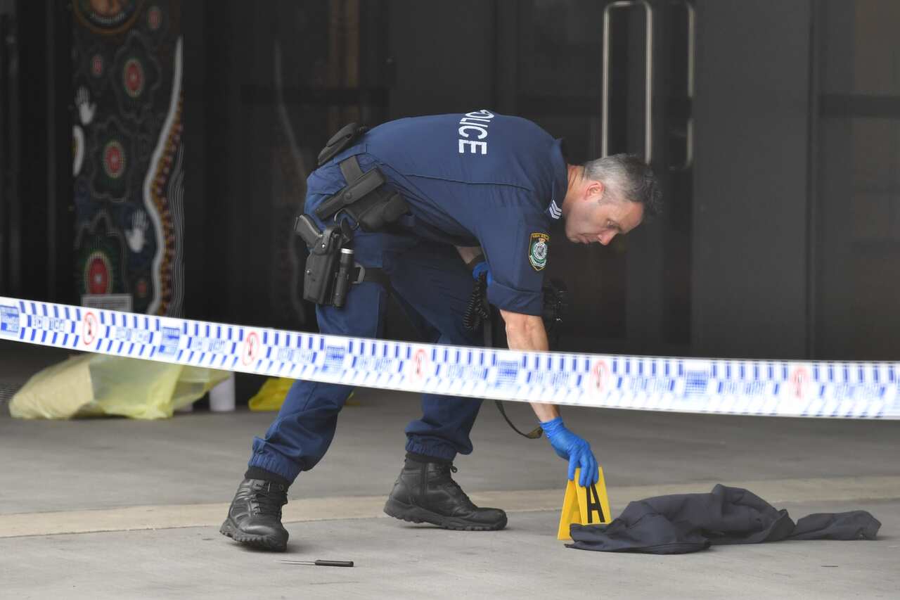 NSW Police look at a small knife at the scene of a stabbing at Arthur Phillip High School in Parramatta, Sydney, Monday, 23 November 23, 2020. 