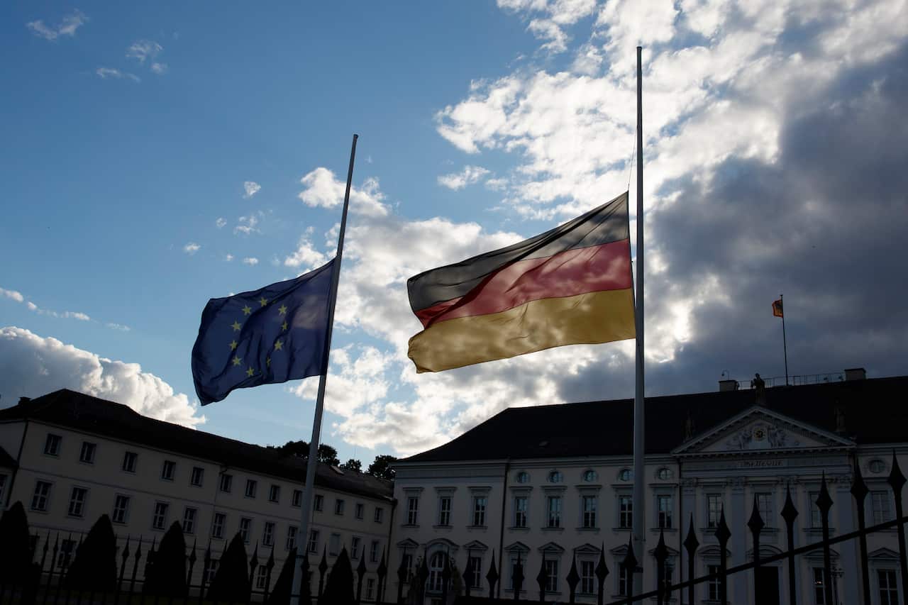 A German national flag and European Union flag fly at half mast after the announcement of the death of the former German Chancellor Helmut Kohl