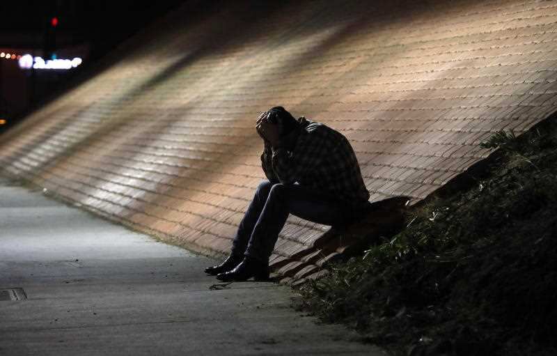  A man holds his head in his hands outside the Borderline Bar and Grill in Thousand Oaks, following the shooting.