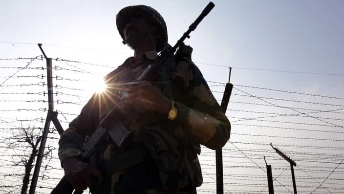 Indian Border Security Force (BSF) soldiers patrol along the fence somewhere at the India-Pakistan border.