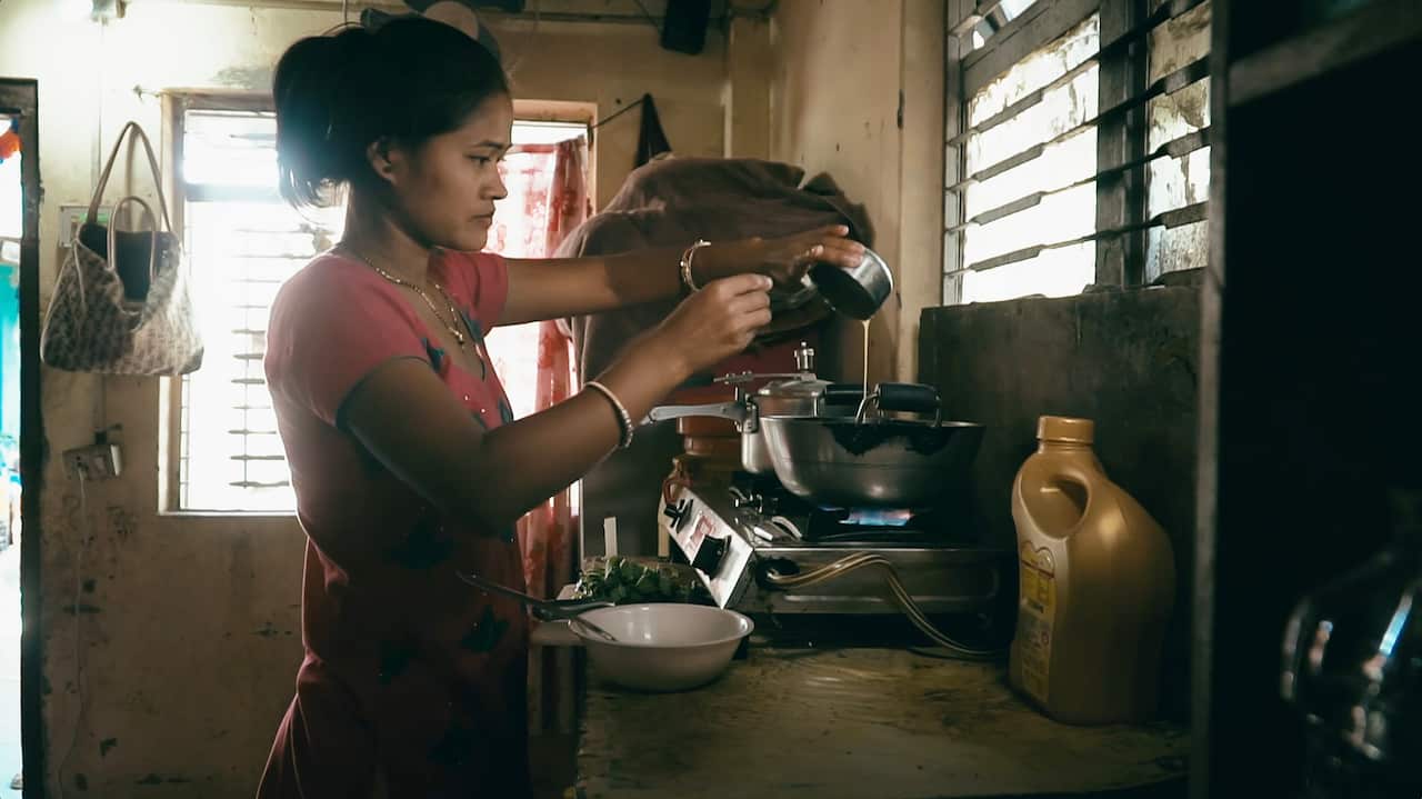 A still from film 'I am Belmaya' where Belmaya can be seen cooking.
