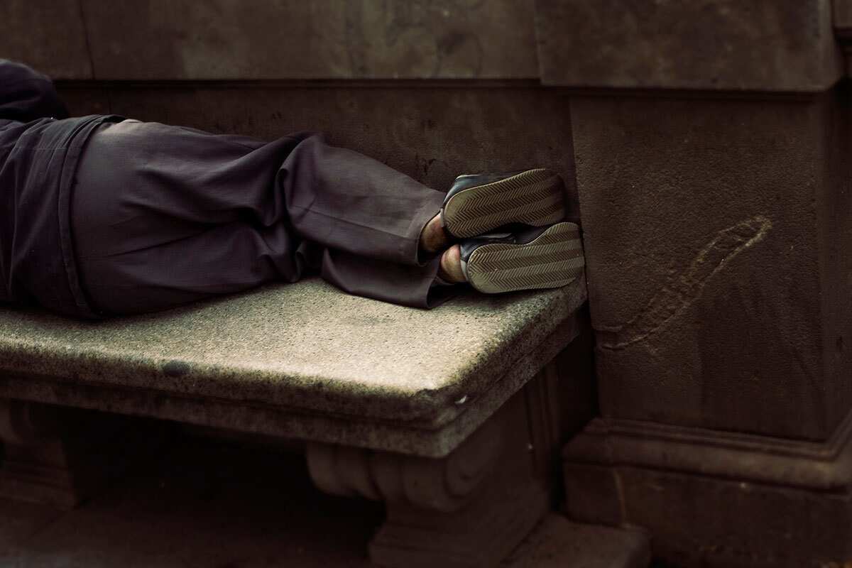 Homeless person sleeping on a bench