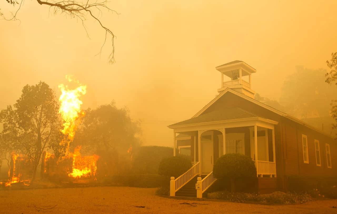 Flames from a propane tank rise as smoke from a wildfire blankets the area on Monday, Oct. 9, 2017, in Napa, Calif. 