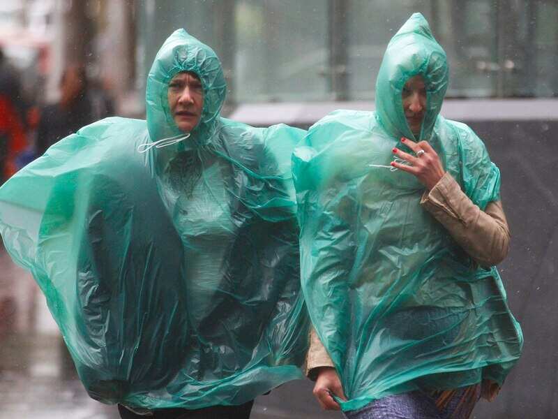People struggle against the heavy rain