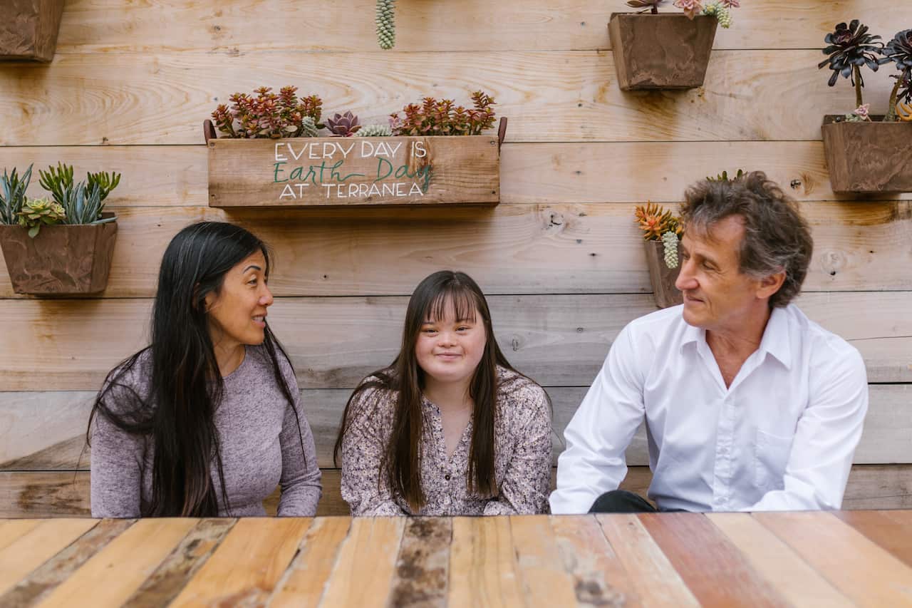 A family sitting on a bench talking together