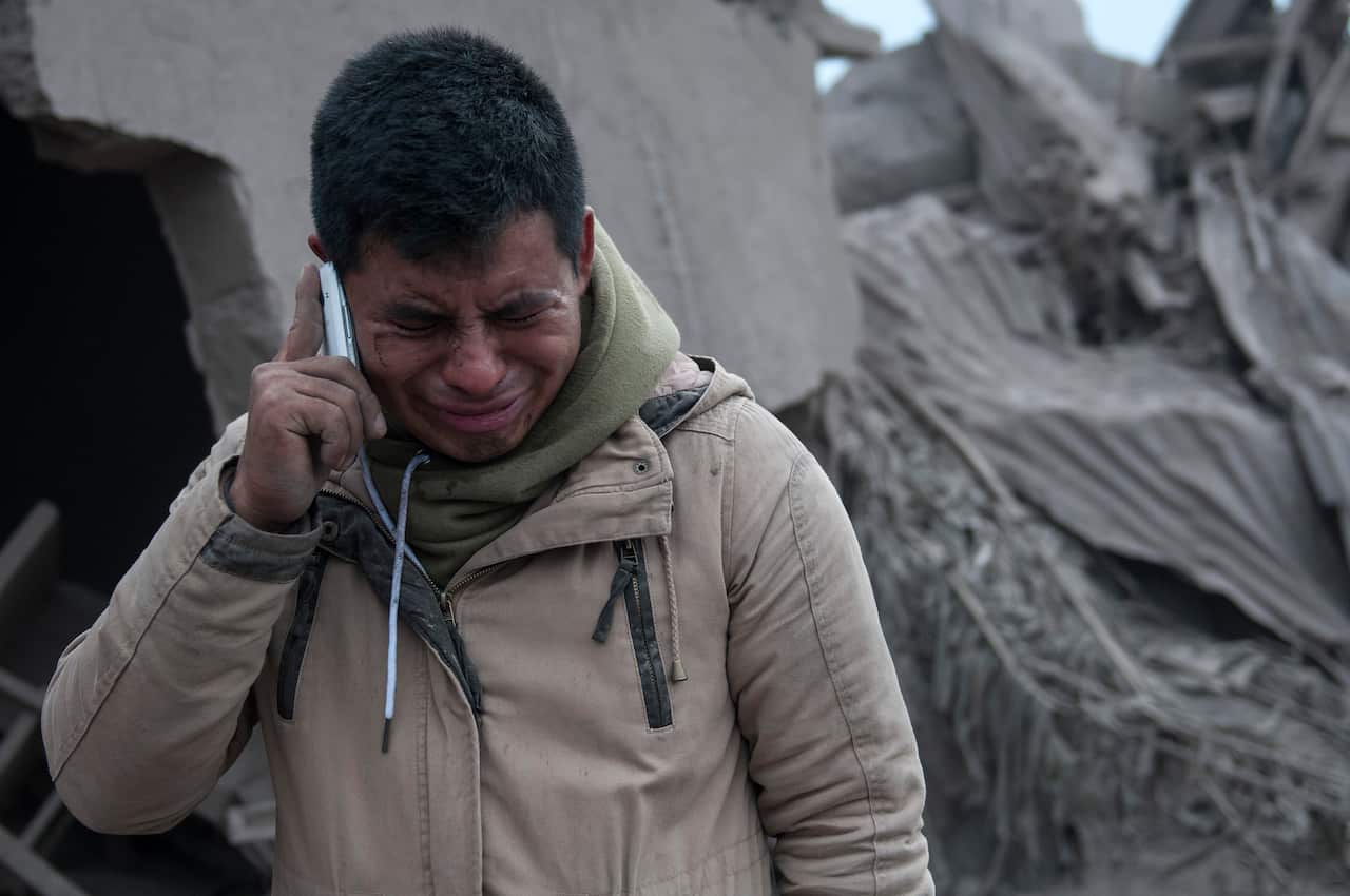 A man cries after reaching his neighborhood near the Volcan de Fuego, or "Volcano of Fire," in Escuintla, Guatemala.