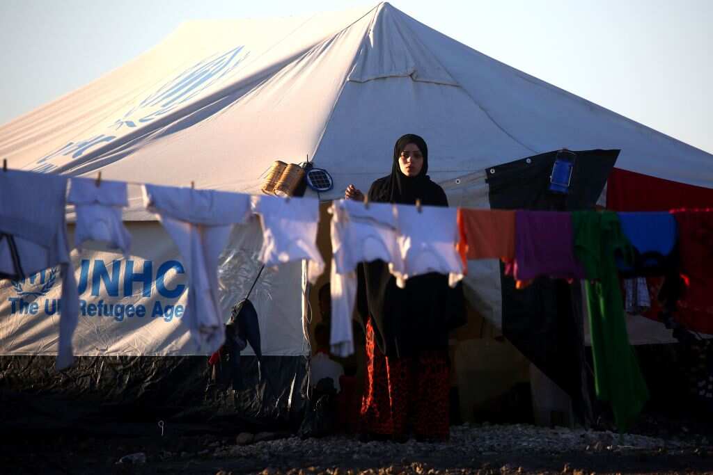 A Syrian woman hangs laundry at a temporary refugee camp in the village of Ain Issa.