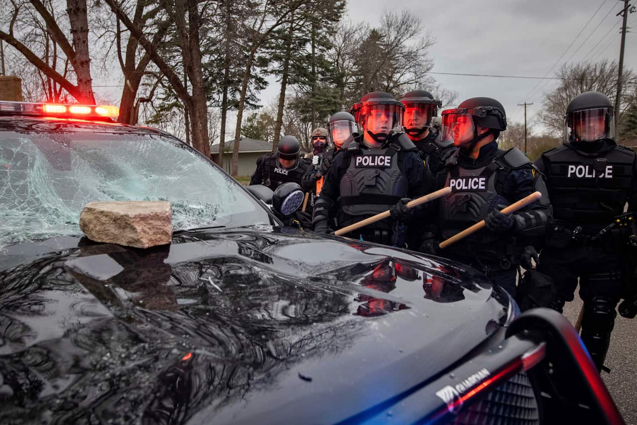 Protesters clash with police after a man was shot and killed by local law enforcement on Sunday April 11, 2021, in Brooklyn Center, Minn.