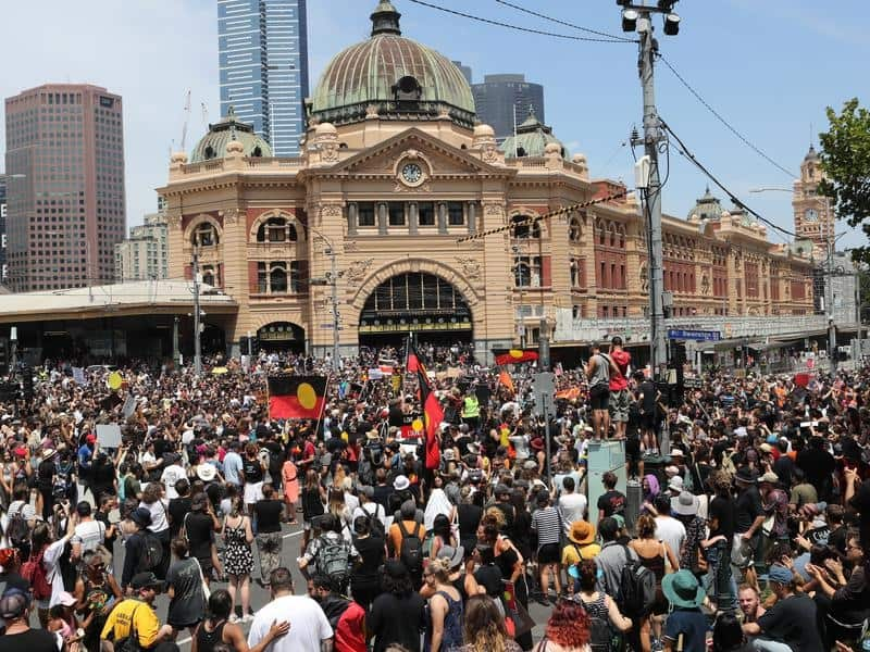 A large crowd of protesters in front of Flinders St Station