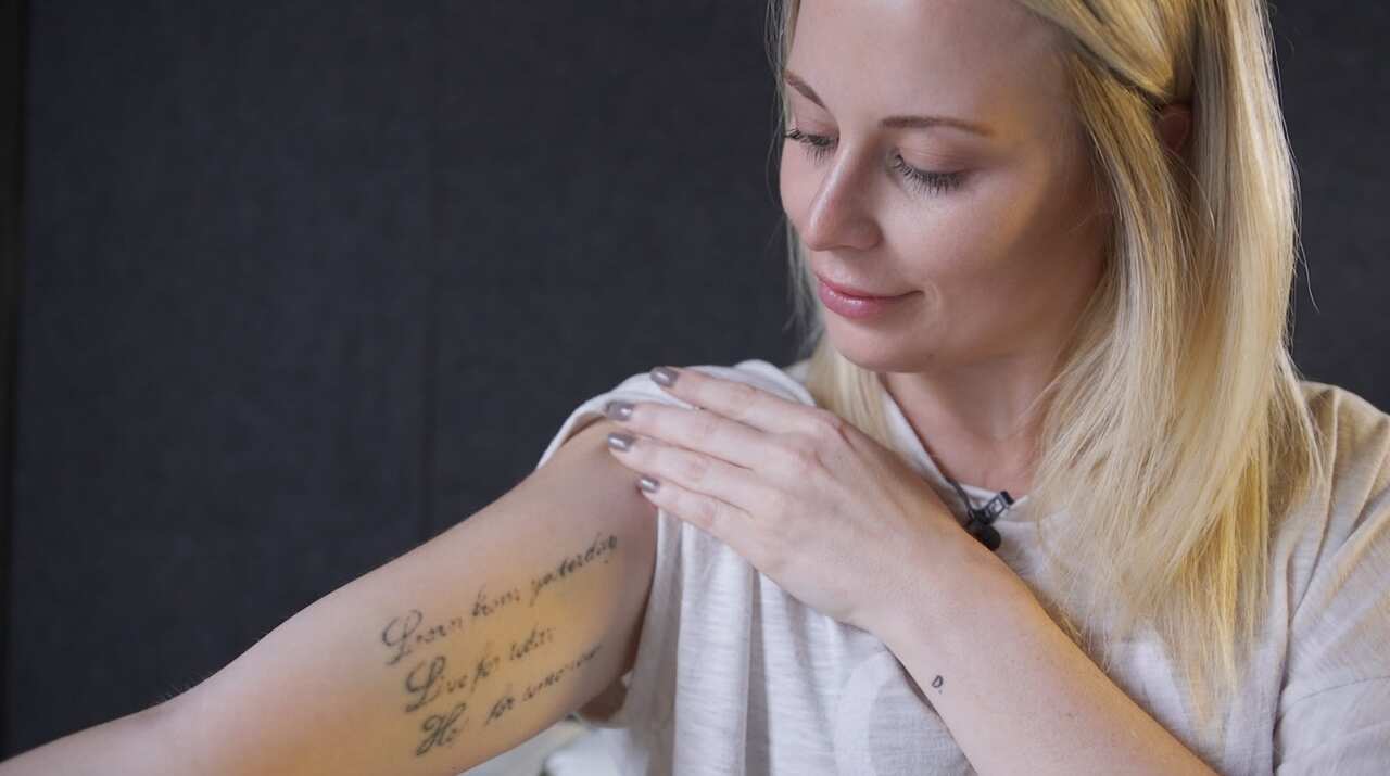 Allysse Tait shows one of two tattoos she's in the process of having removed.
