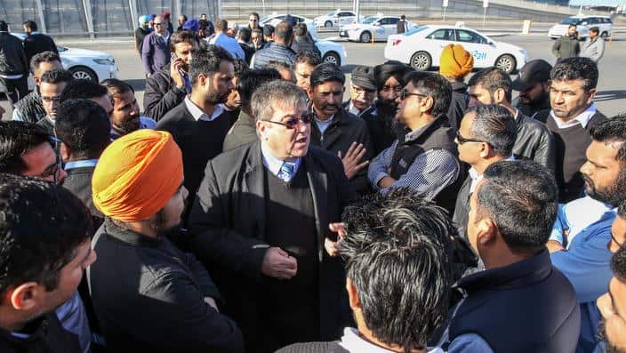 President of Taxi Council of South Australia, Jim Triantafyllou (c) with taxi drivers during a protest at Adelaide airport