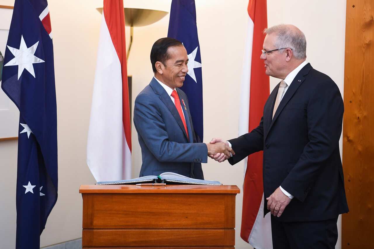 Indonesian President Joko Widodo shakes hands with Australian Prime Minister Scott Morrison after signing the official visitors book at Parliament House.