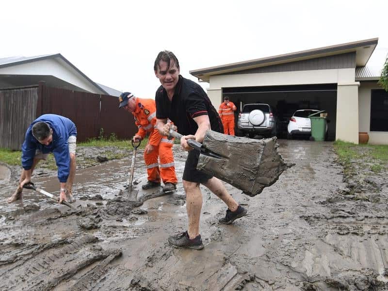 Andrew Hodgson cleans mud off his driveway in Townsville