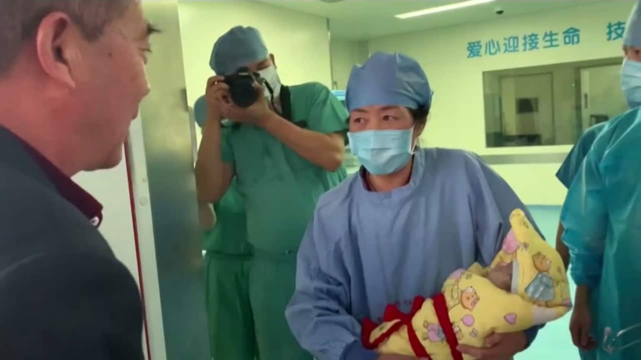 A midwife holding the baby