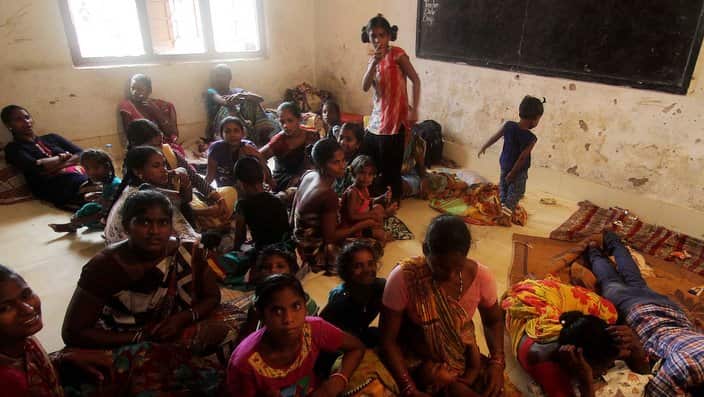 Locals and fishermen take shelter in a makeshift shelter home at Konark in Puri district on the eve of cyclone Fani's landfall in Odisha coast, India.