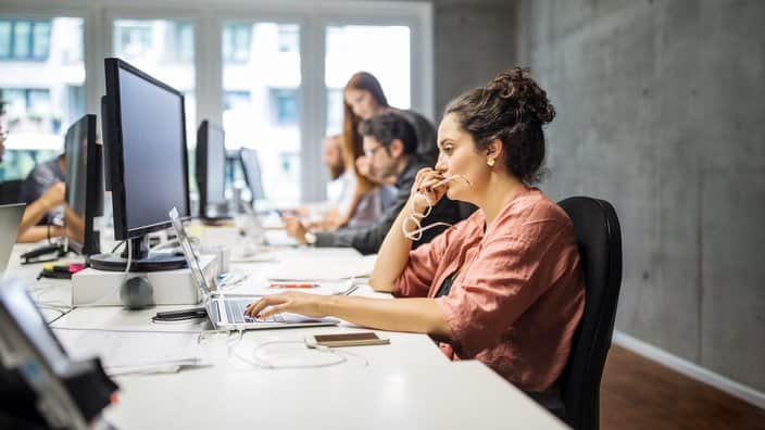 Serious businesswoman using laptop in creative office