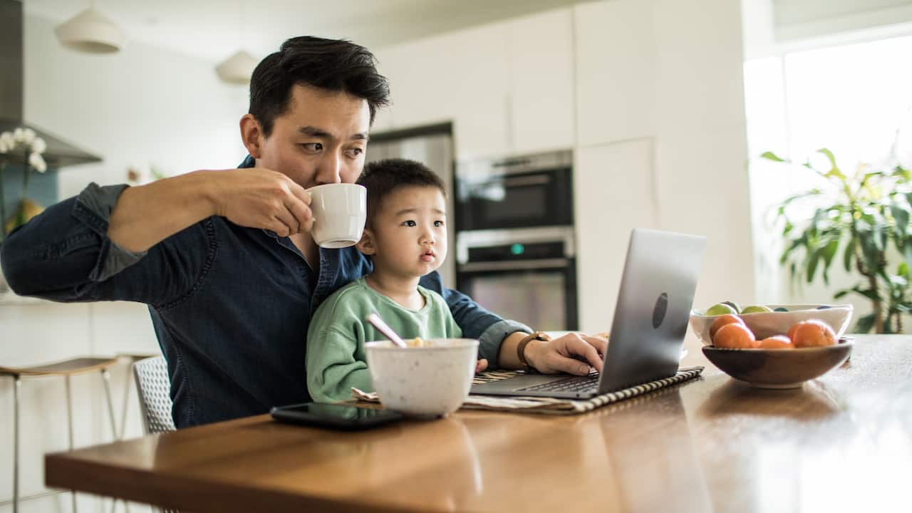 Father and son having breakfast while working 
