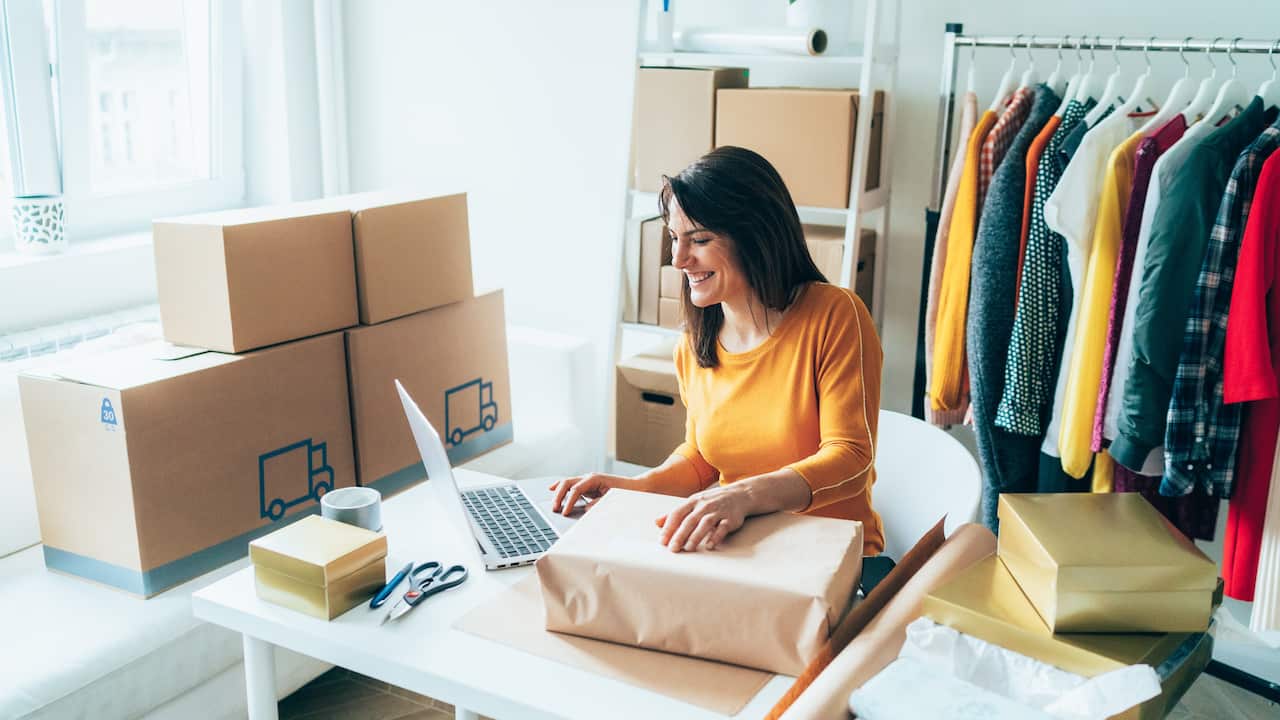 A woman is preparing a package for delivery to clients 
