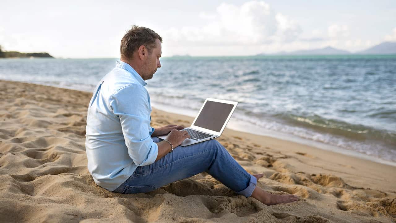 Man with a laptop on beach