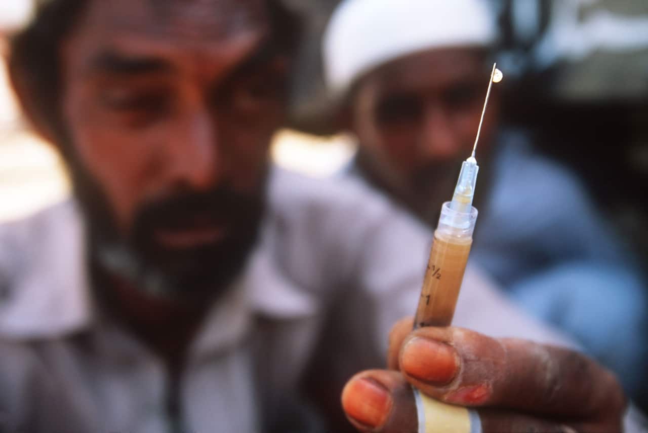 Drug addict holding needle ready for injection
