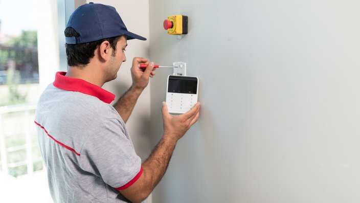 Man installing security alarm system