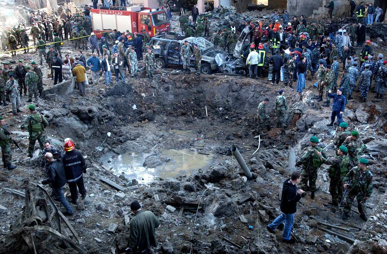 Feb 14 2005 rescue workers and soldiers stand around a massive crater after a bomb attack that tore through the motorcade of former Prime Minister Rafik Hariri 