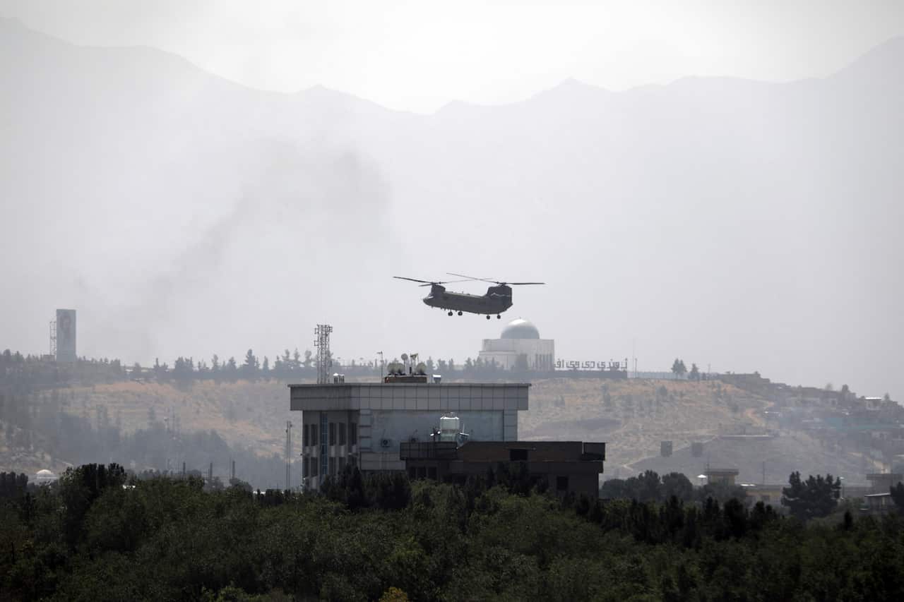 A US Chinook helicopter flies over the U.S. Embassy in Kabul, Afghanistan, Sunday, Aug. 15, 2021. 