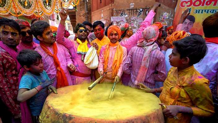 People seen playing the drum before starting the  Holi Festival in India