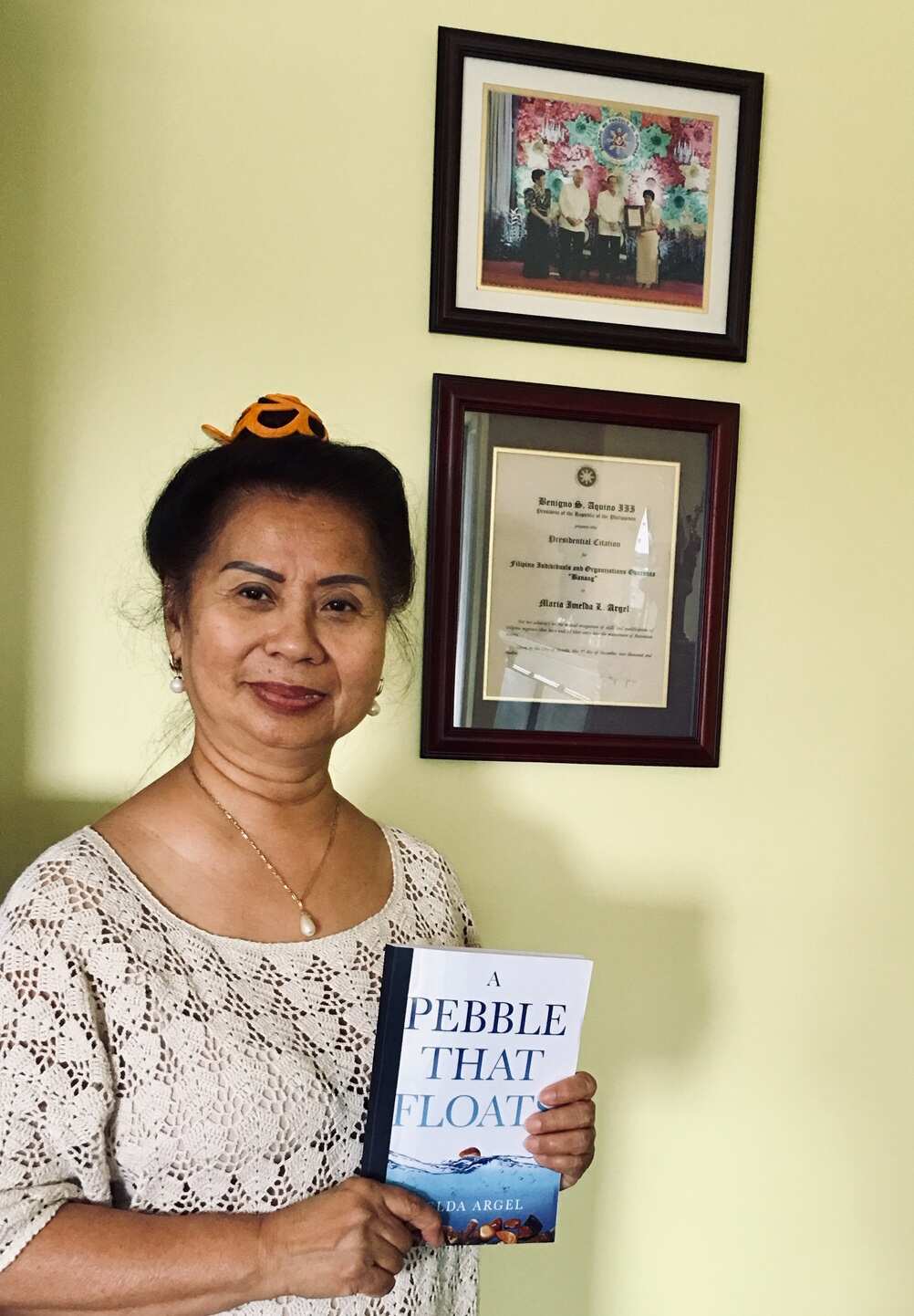 Imelda with her memoir and her award from the Philippine government on the background 