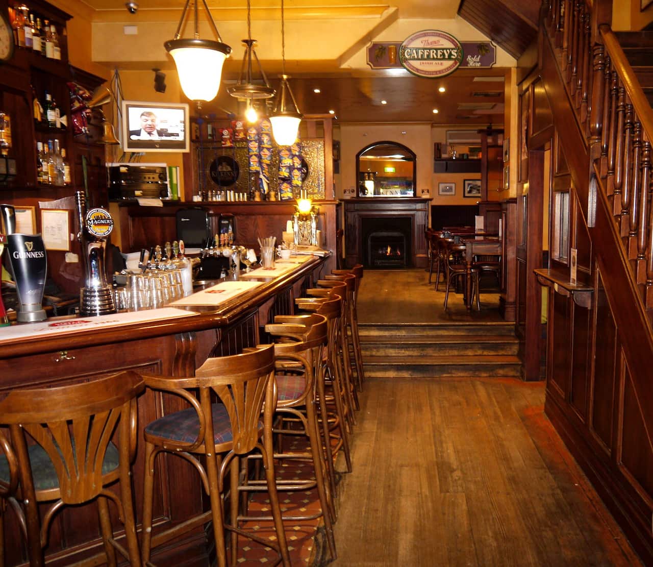 Empty seats at the bar in an otherwise bustling pub owned by Mr Singh.
