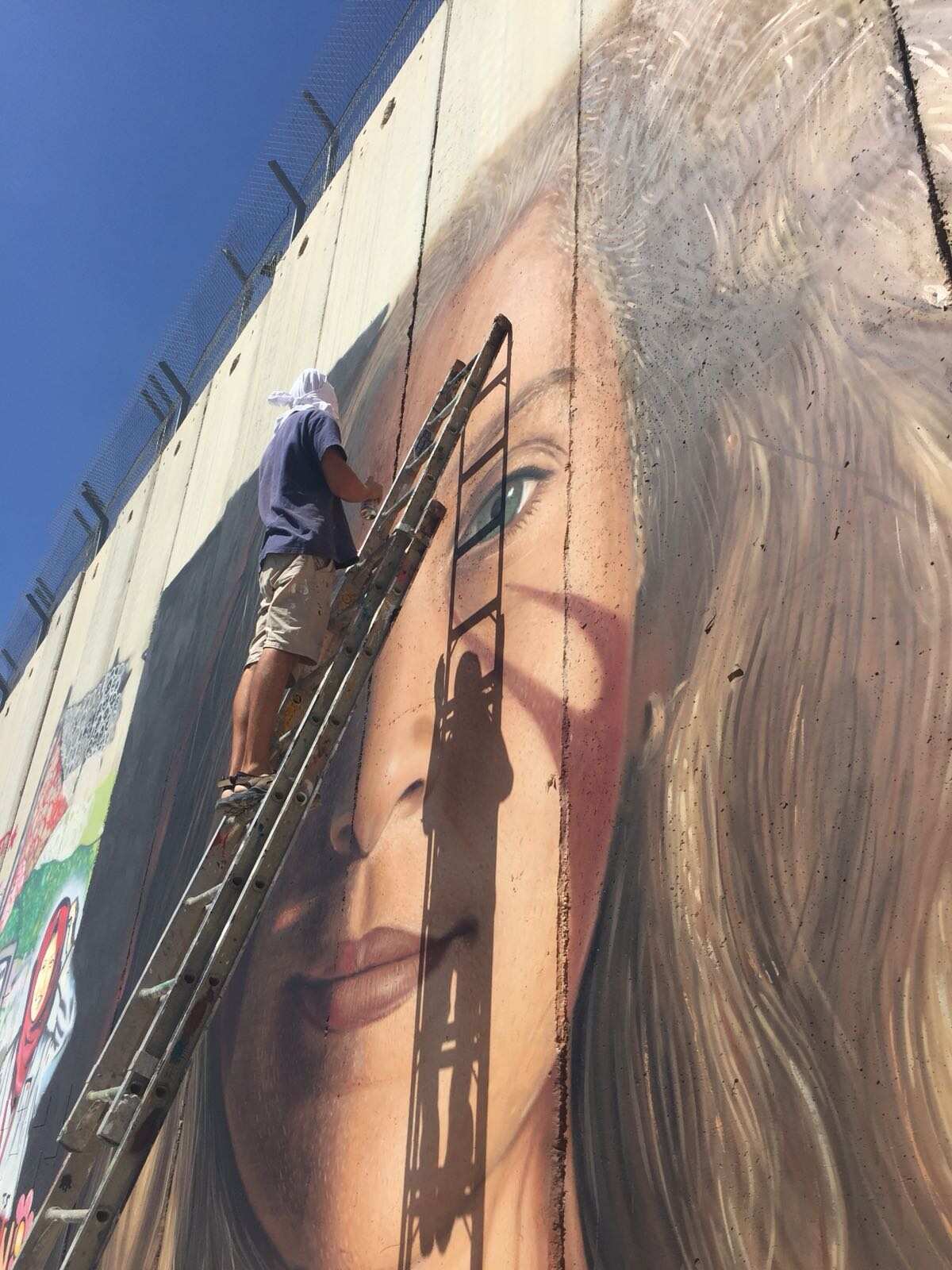 L'artista campano Jorit durante la realizzazione del ritratto di Ahed Tamimi.