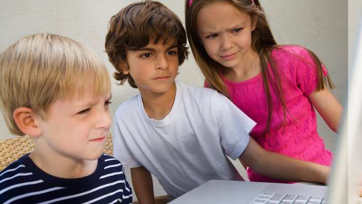 Concerned Kids Looking at a Laptop