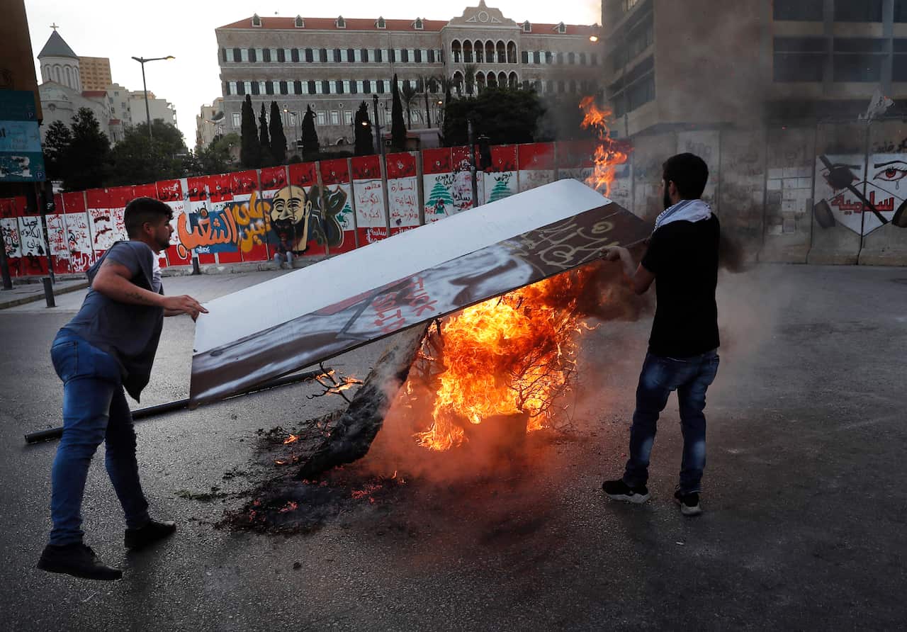 Anti-government protesters burn tires and woods during a protest against the political leadership in front the government house in Beirut , June 11, 2020