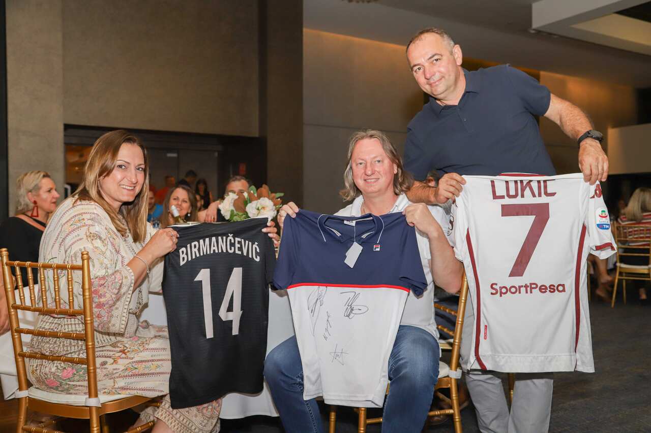 Nebojsa Stevanovic (right), Zoran and Lidija Ilic with football jerseys purchased during a charity event in the Serbian Centre in Bonnyrigg  