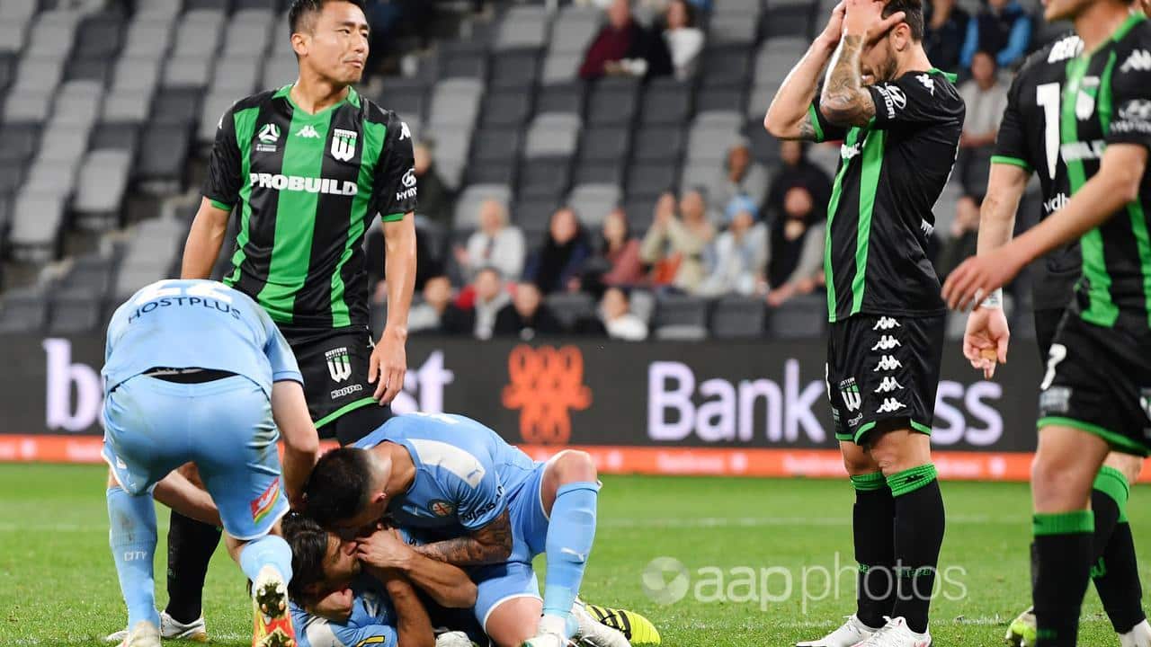 Melbourne City players celebrate as their Western United opponents are crestfallen by an own goal, 26 Aug 2020.