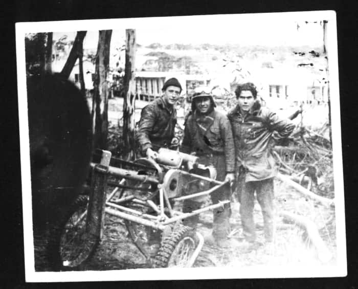 Luciano con due colleghi posano con una motosega degli anni Cinquanta.