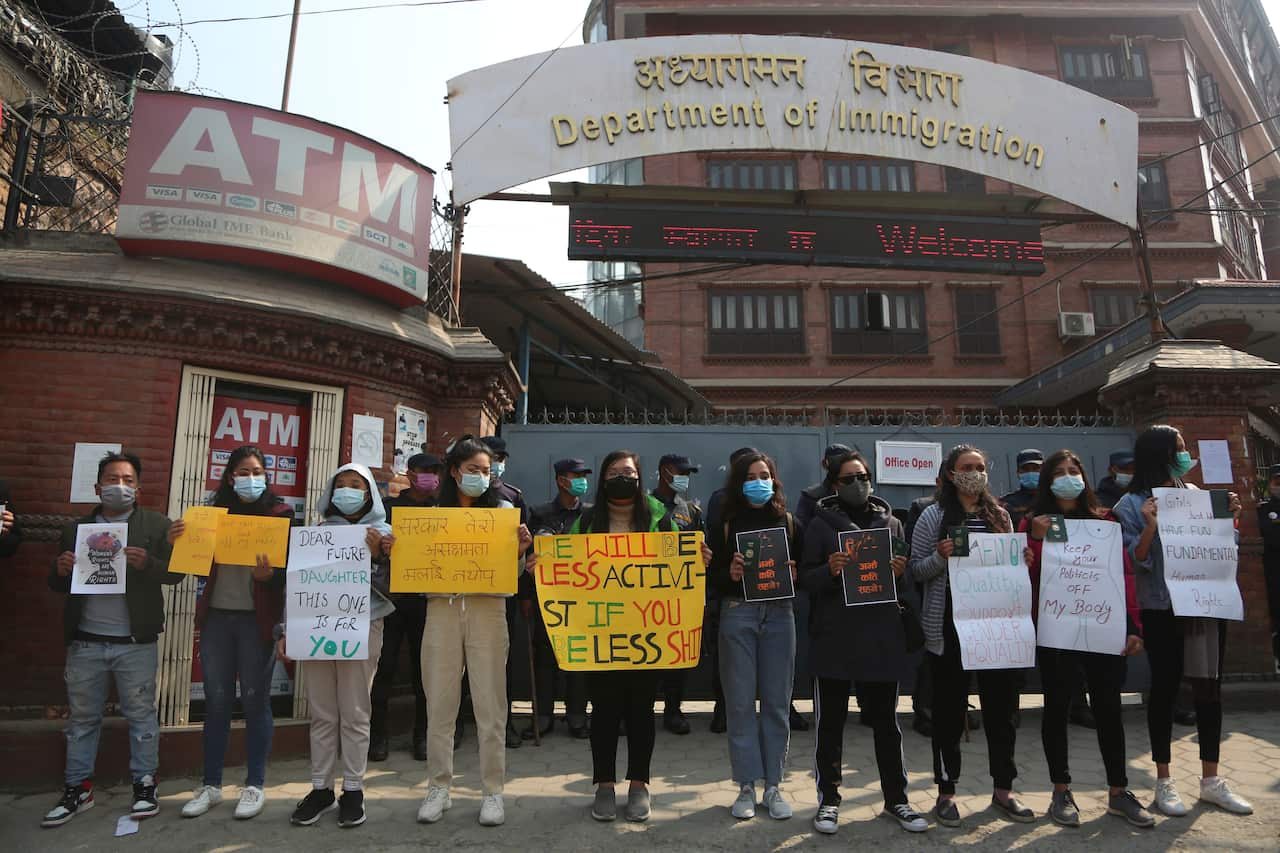 Nepal women hold placards against a proposed rule which restricts foreign travel for women under 40 years, Thursday, Feb.11, 2021. (AP Photo/Niranjan Shrestha)