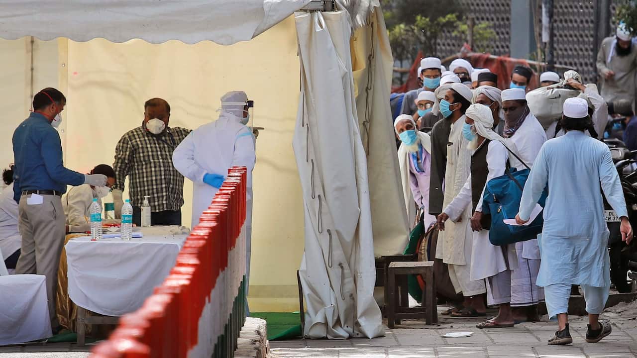 Indian paramedics note down names of Muslims pilgrims before they are taken to a quarantine facility, amid concerns over the spread of the new coronavirus, at the Nizamuddin area of New Delhi, India,