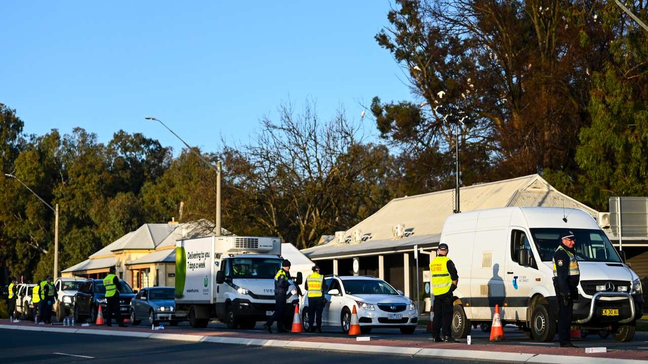 NSW police officers check cars crossing at a border check point.