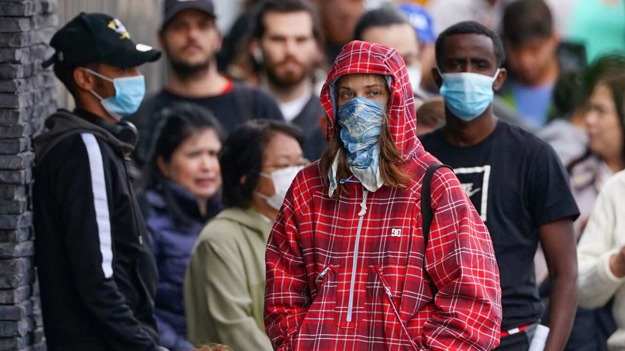 People are seen in long queue outside a Centrelink office in Abbotsford, Melbourne