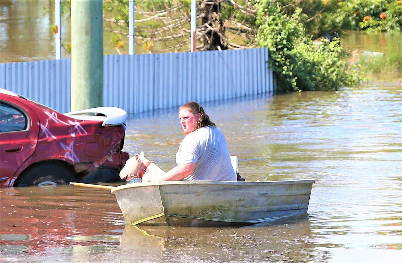 A resident evacuates his flooded house in Logan, south of Brisbane, as the suburb reached its peak, Tuesday, March 1, 2022. 