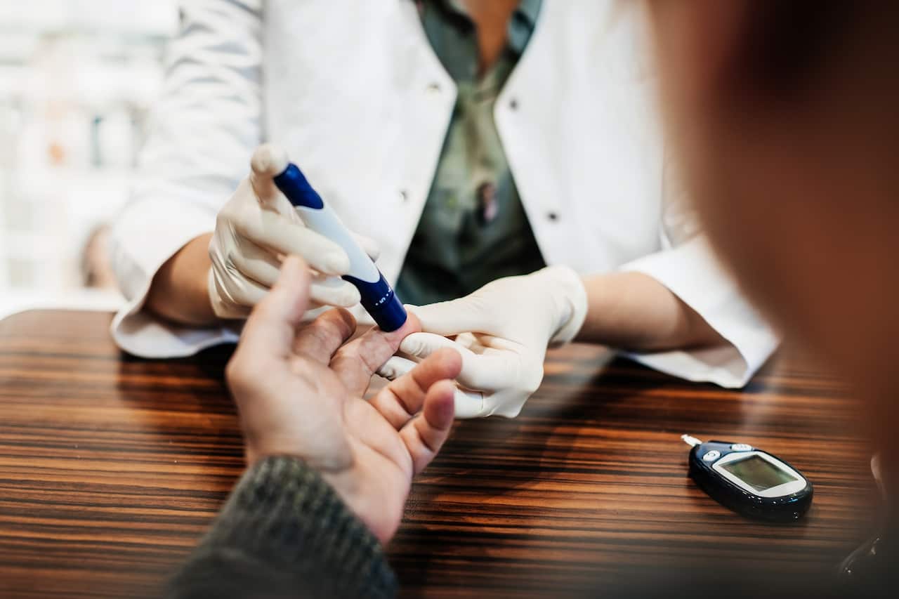 Pharmacist Checking Customer's Blood Sugar Levels