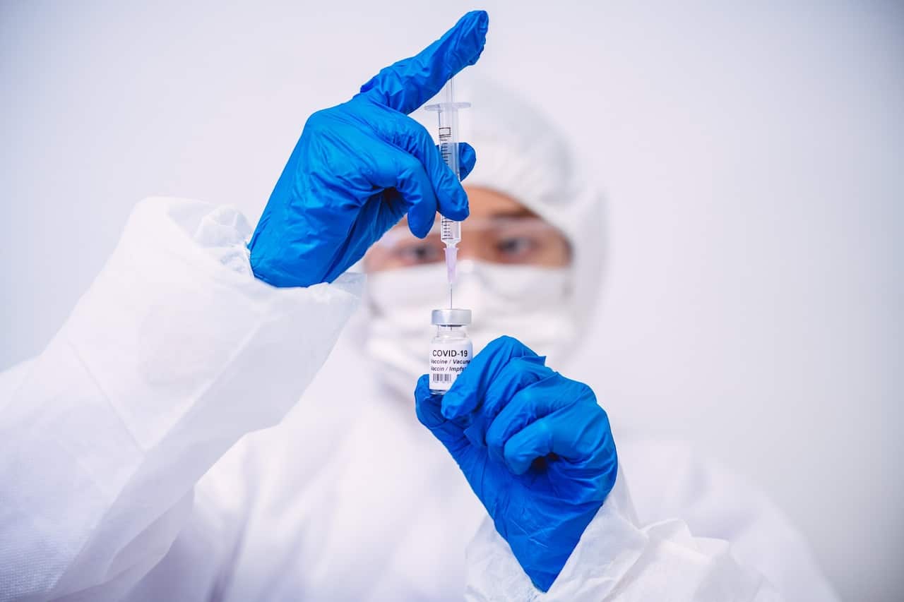 A doctor fills an injection syringe with COVID-19 vaccine 