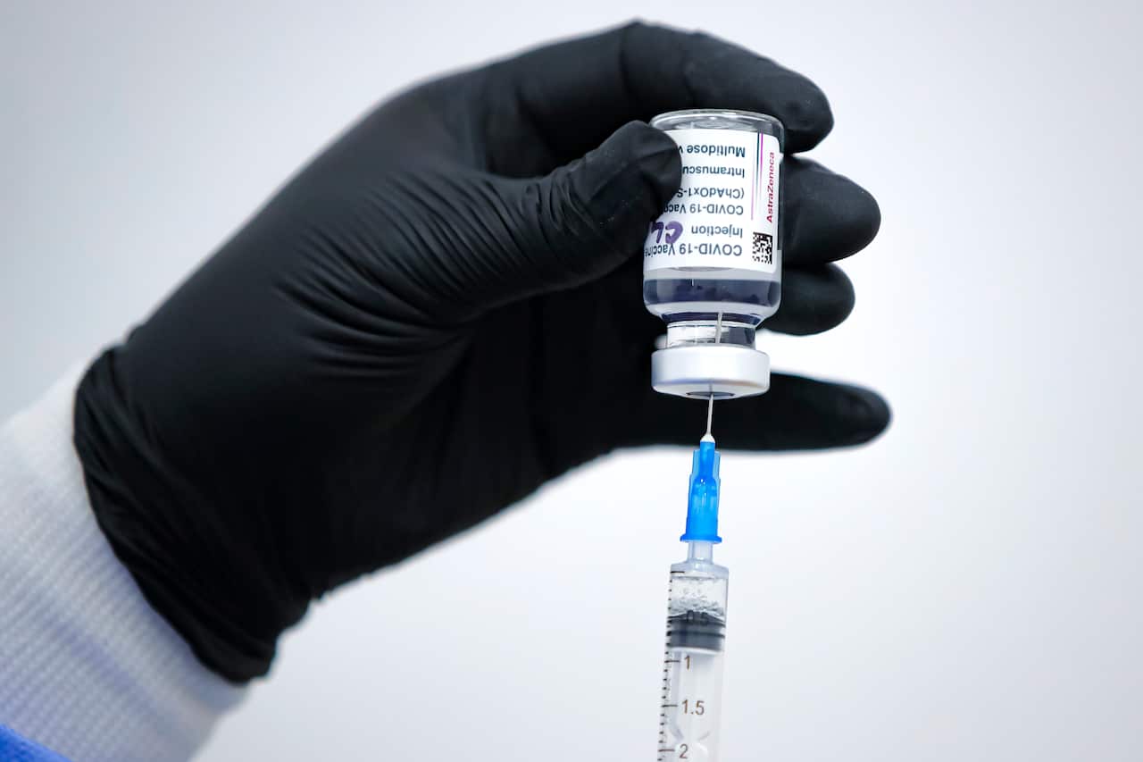A member of the medical staff draws serum from an AstraZeneca vaccine container at a vaccination center in Bucharest, Romania, Wednesday, April 7, 2021. 