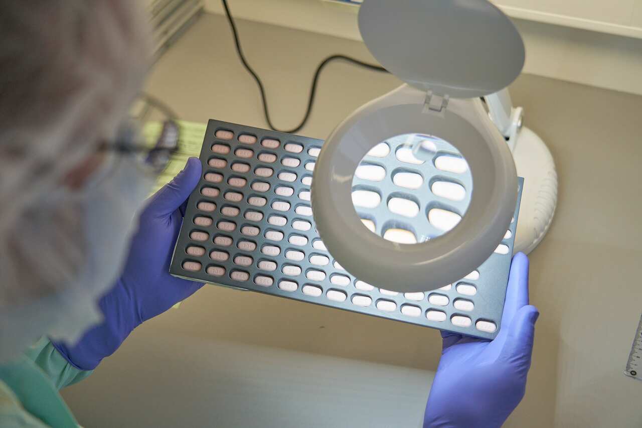 A Pfizer lab technician visually inspects Paxlovid tablet samples in Freiburg, Germany (Suppled - Pfizer).