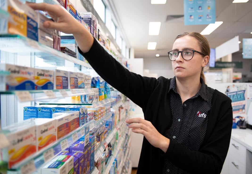 A pharmacist reaches for medicine at a shop in Coburg, Melbourne.
