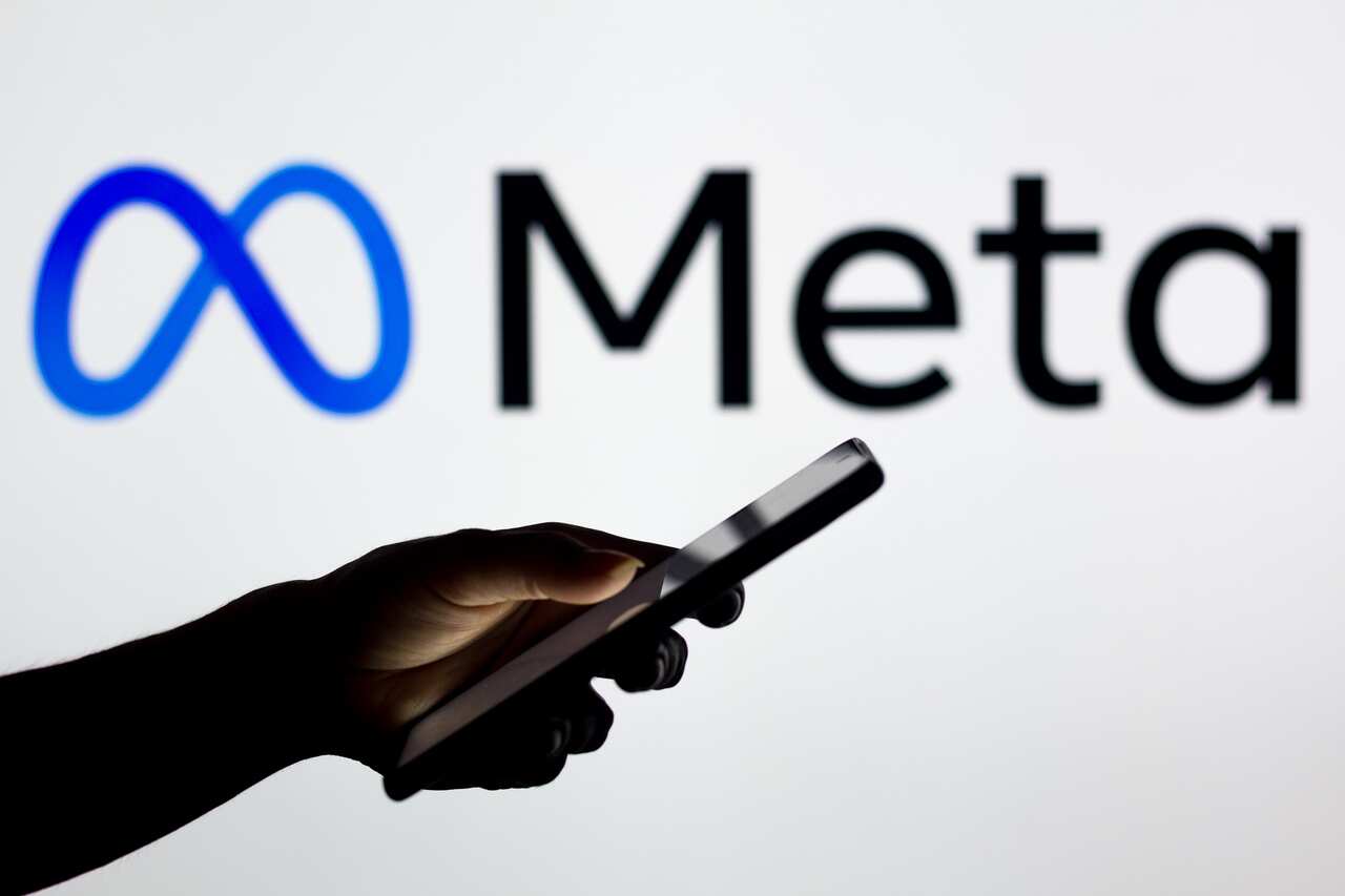 In this photo illustration the Meta Platforms logo seen in the background of a silhouette woman holding a mobile phone. (Photo by Rafael Henrique / SOPA Images/Sipa USA)