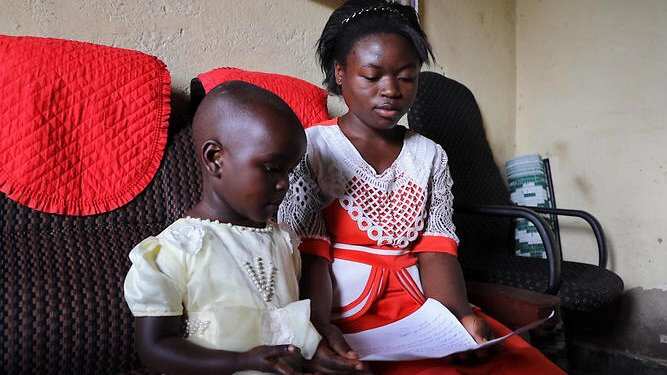 Ghislene and her sister Yuha with a letter they wrote to Australia’s PM asking to help children who have lost their parents to Ebola