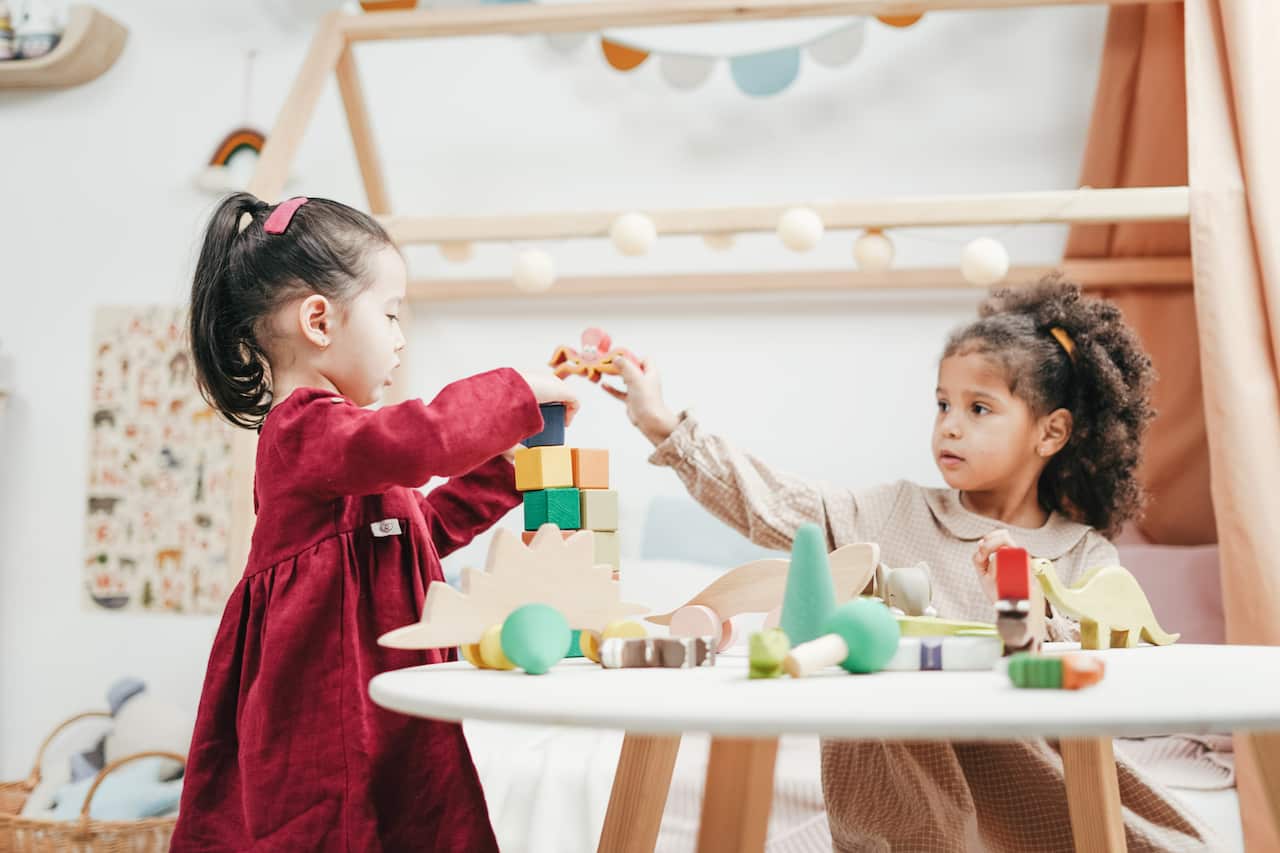 Girl in red dress playing with wooden blocks