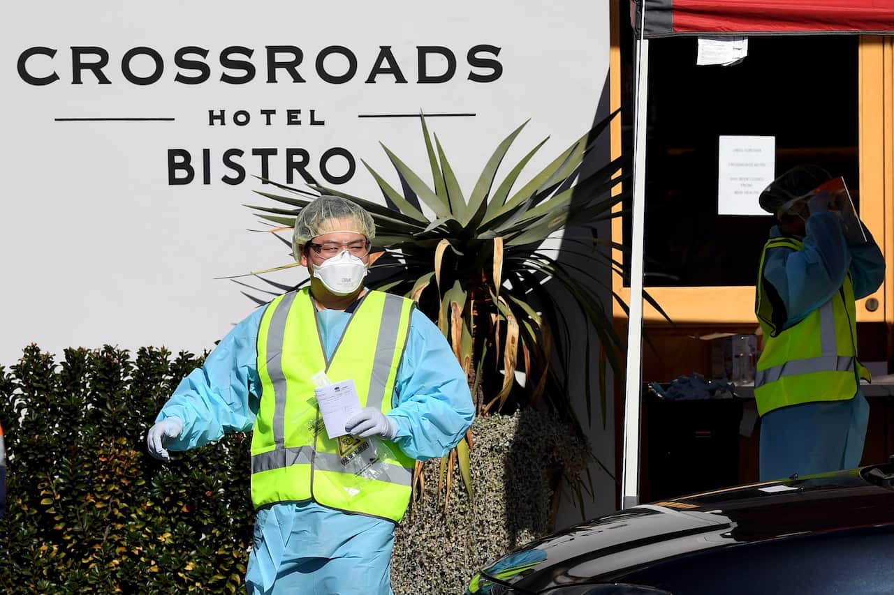 NSW Health workers dressed in Personal Protective Equipment (PPE) are seen administering COVID-19 tests to people in their cars at the Crossroads Hotel testing centre in Sydney, Monday, July 13, 2020. (AAP Image/Joel Carrett) NO ARCHIVING